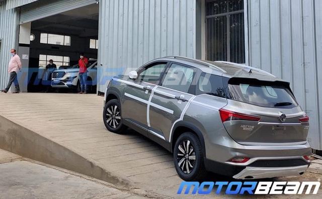 A new set of spy photos confirm that the soon-to-be-launched MG Hector Plus has now started reaching dealership stockyards, indicating that the company has commenced despatches of the SUV.