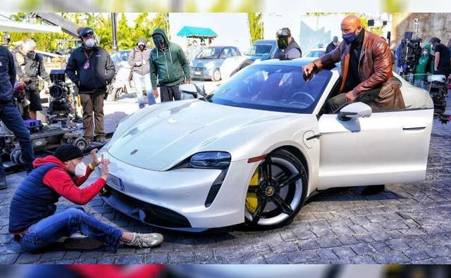 The Porsche Taycan is part of Dwayne Johnson's next production Red Notice, but he couldn't drive the electric supercar. Read on to find out why.